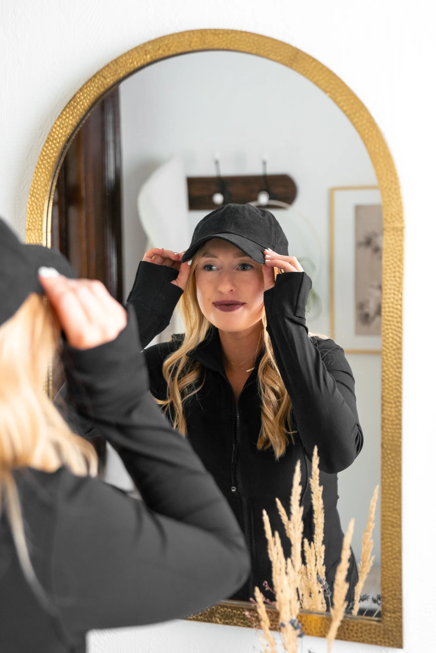 our skin-focused nutritionist putting on a hat in a mirror